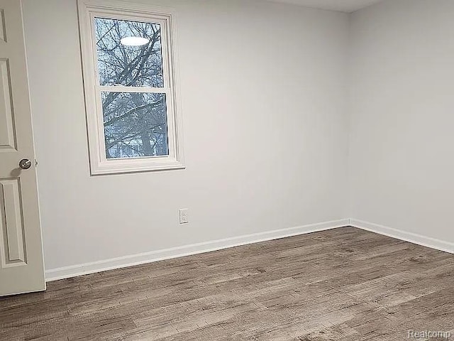 513 W Kilborn St, Lansing, MI 48906 - spare room with dark wood-type flooring and baseboards