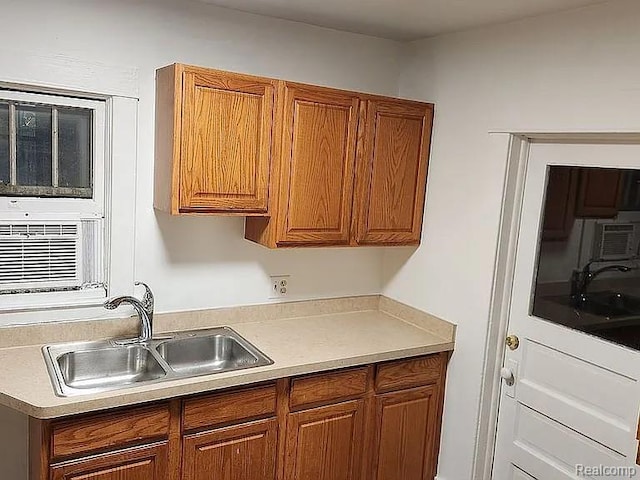 513 W Kilborn St, Lansing, MI 48906 - kitchen with a sink, brown cabinetry, light countertops, and cooling unit