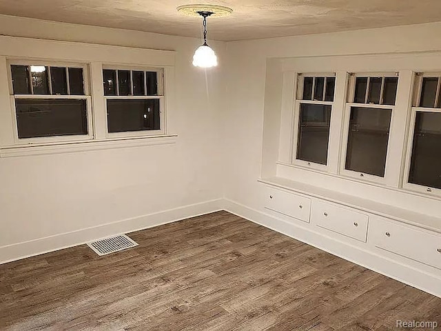 513 W Kilborn St, Lansing, MI 48906 - unfurnished dining area featuring dark wood-type flooring and baseboards