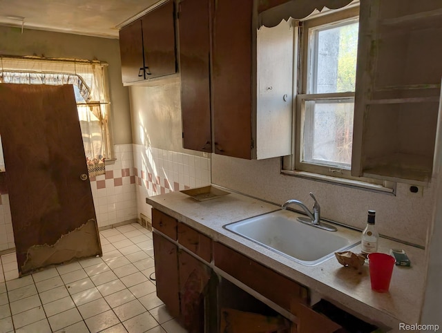 17224 Waveney St, Detroit, MI 48224 - kitchen featuring a sink, plenty of natural light, light tile patterned floors, tile walls, and a wainscoted wall