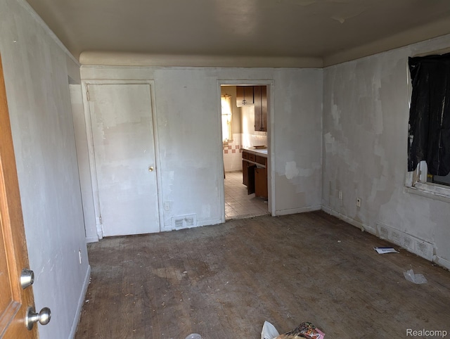 17224 Waveney St, Detroit, MI 48224 - unfurnished bedroom with wood finished floors, baseboards, and connected bathroom