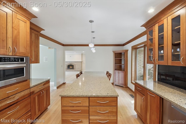 4335 Queens Way, Bloomfield Hills, MI 48304 - kitchen featuring stainless steel oven, light wood-style floors, ornamental molding, glass insert cabinets, and a brick fireplace