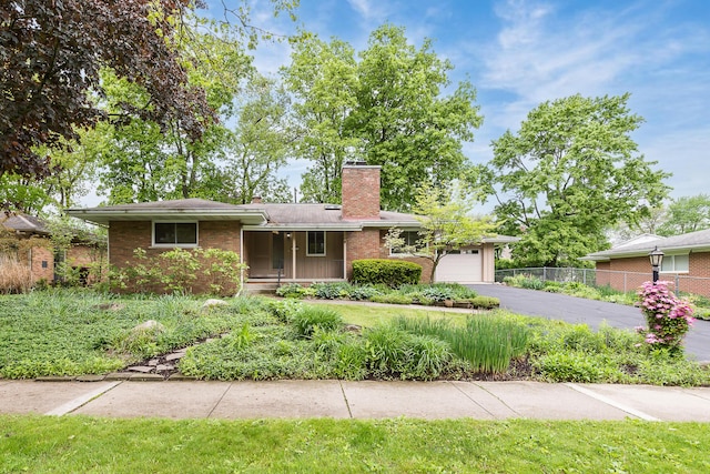 1134 Meadowbrook Ave, Ann Arbor, MI 48103 - ranch-style house featuring a chimney, brick siding, asphalt driveway, and an attached garage