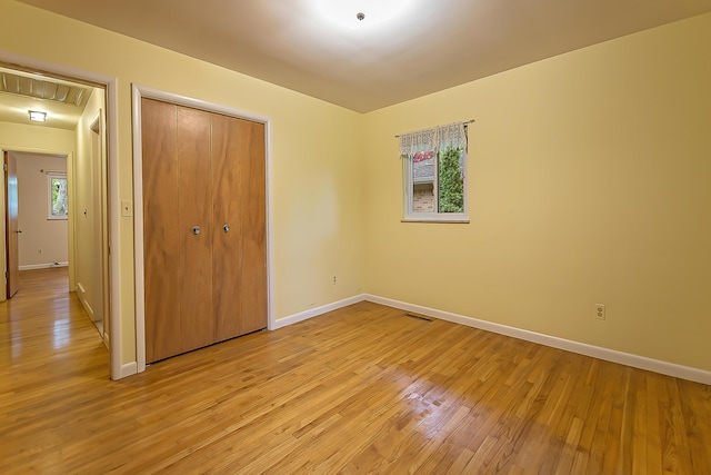1134 Meadowbrook Ave, Ann Arbor, MI 48103 - unfurnished bedroom featuring baseboards, a closet, light wood-style flooring, and attic access