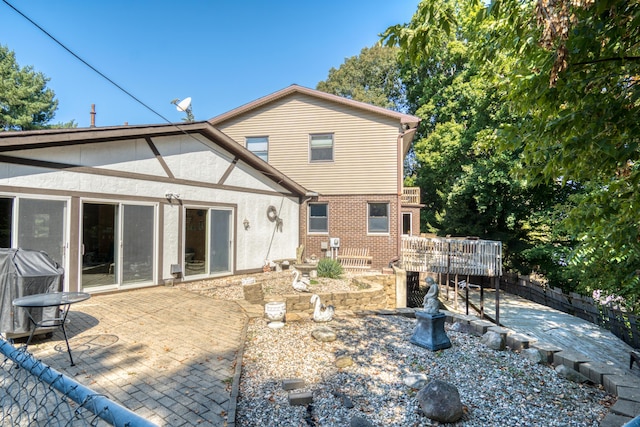 610 Birch St, Big Rapids, MI 49307 - back of house featuring a patio area, stucco siding, and a wooden deck
