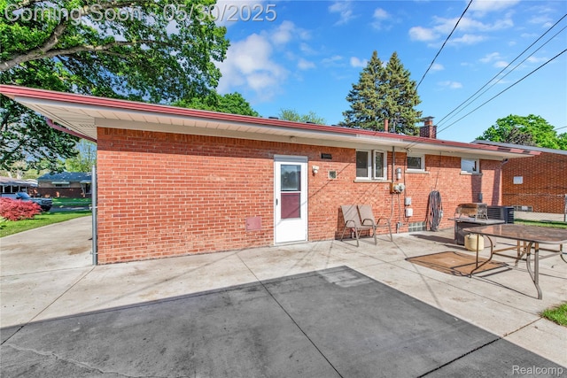 32601 Grinsell Dr, Warren, MI 48092 - back of property featuring brick siding, a patio, central air condition unit, and a chimney