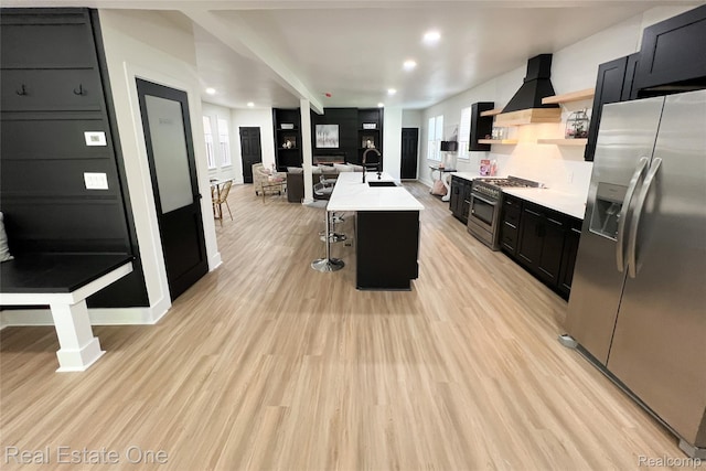 3461 Sheridan St, Detroit, MI 48214 - kitchen featuring stainless steel appliances, dark cabinets, wall chimney range hood, a sink, and light countertops
