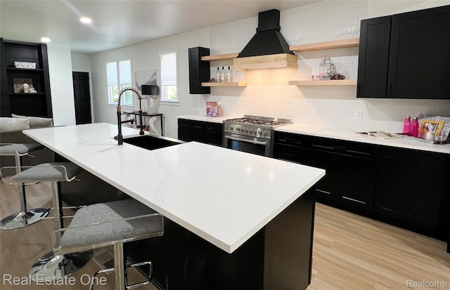 3461 Sheridan St, Detroit, MI 48214 - kitchen with dark cabinetry, high end stainless steel range, a sink, custom range hood, and open shelves