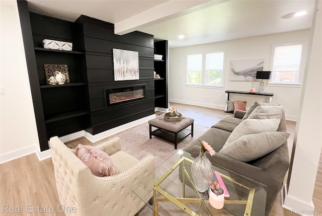 3461 Sheridan St, Detroit, MI 48214 - living room featuring a glass covered fireplace, light wood-style flooring, baseboards, and beam ceiling