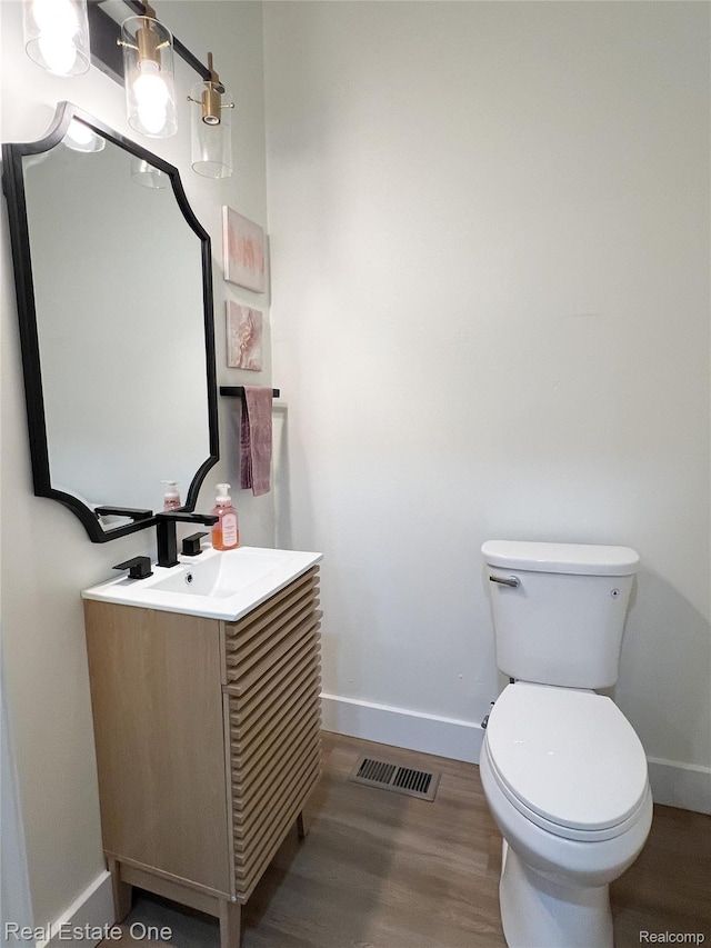 3461 Sheridan St, Detroit, MI 48214 - bathroom with baseboards, vanity, toilet, and wood finished floors