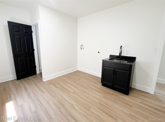 3461 Sheridan St, Detroit, MI 48214 - unfurnished room featuring a sink, light wood-style flooring, and baseboards