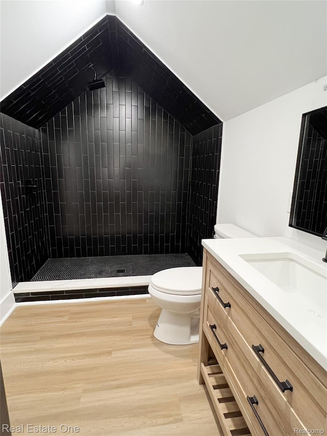 3461 Sheridan St, Detroit, MI 48214 - full bath with vanity, toilet, lofted ceiling, tiled shower, and wood finished floors