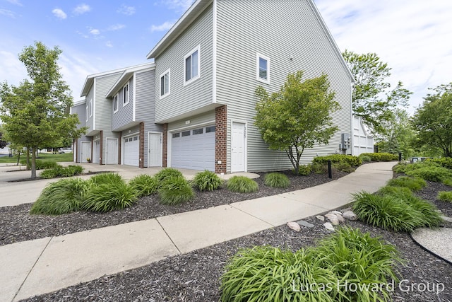 301 NW Xing Unit 25, Holland, MI 49423 - view of side of property featuring a garage and brick siding