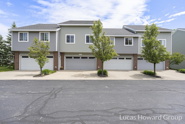 301 NW Xing Unit 25, Holland, MI 49423 - view of front facade featuring brick siding, a garage, and driveway