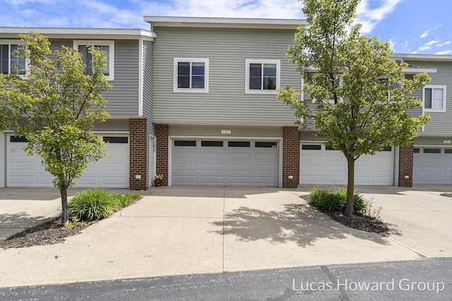 301 NW Xing Unit 25, Holland, MI 49423 - view of property featuring brick siding, driveway, and a garage