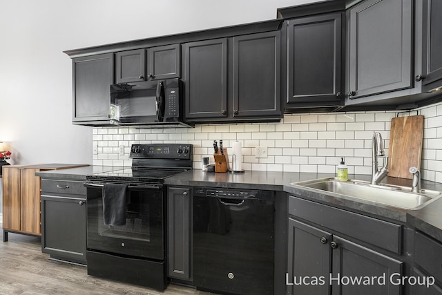 301 NW Xing Unit 25, Holland, MI 49423 - kitchen with black appliances, a sink, dark countertops, light wood finished floors, and backsplash