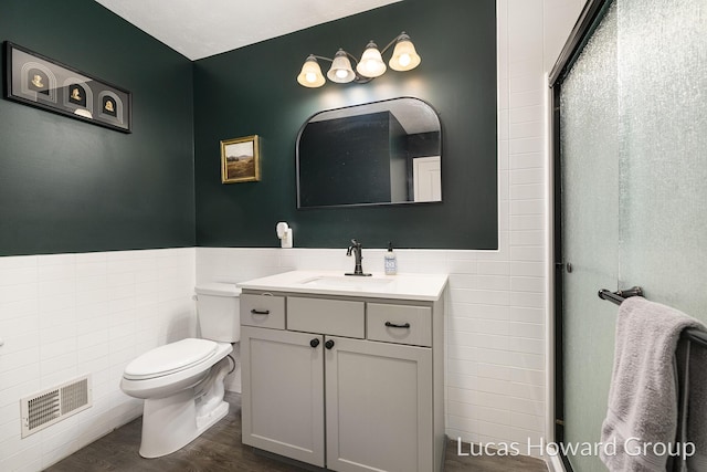 301 NW Xing Unit 25, Holland, MI 49423 - full bathroom featuring tile walls, toilet, vanity, wood finished floors, and wainscoting