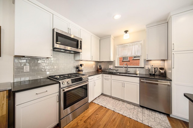 1537 Marian Ave, Ann Arbor, MI 48103 - kitchen with stainless steel appliances, a sink, light wood-style flooring, tasteful backsplash, and recessed lighting