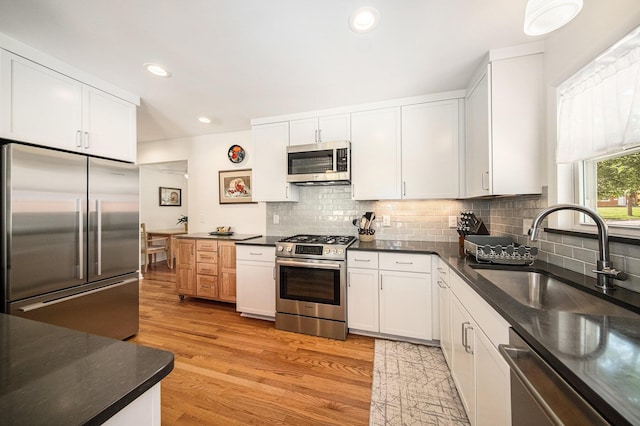 1537 Marian Ave, Ann Arbor, MI 48103 - kitchen with appliances with stainless steel finishes, a sink, decorative backsplash, light wood-style floors, and recessed lighting