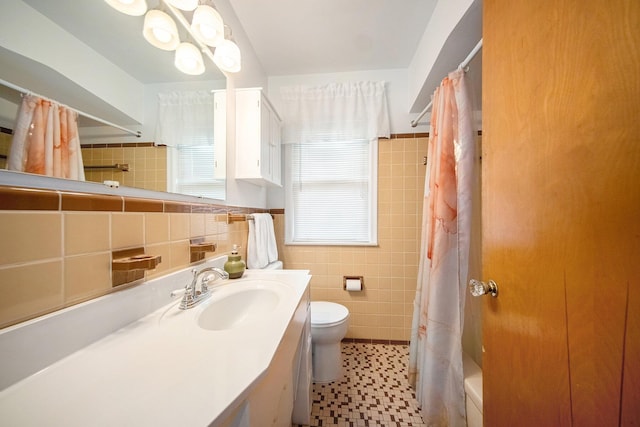 1537 Marian Ave, Ann Arbor, MI 48103 - bathroom featuring tile walls, toilet, vanity, and shower / tub combo