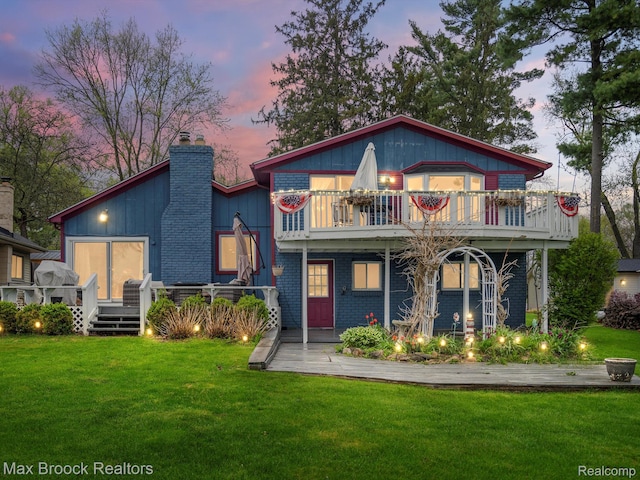 9431 Mandon Rd, White Lake, MI 48386 - rear view of house featuring a chimney, a lawn, and a deck