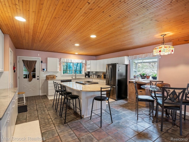 9431 Mandon Rd, White Lake, MI 48386 - kitchen featuring freestanding refrigerator, a sink, white cabinetry, healthy amount of natural light, and recessed lighting