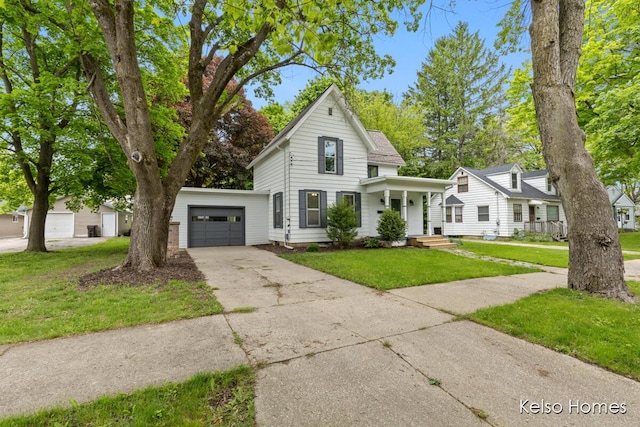 510 Division St, Big Rapids, MI 49307 - view of front facade featuring an attached garage, driveway, a front lawn, and a porch