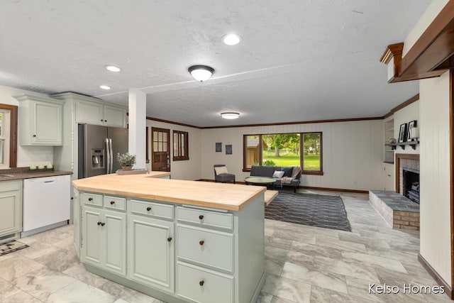 510 Division St, Big Rapids, MI 49307 - kitchen featuring white dishwasher, stainless steel fridge with ice dispenser, butcher block counters, open floor plan, and a brick fireplace