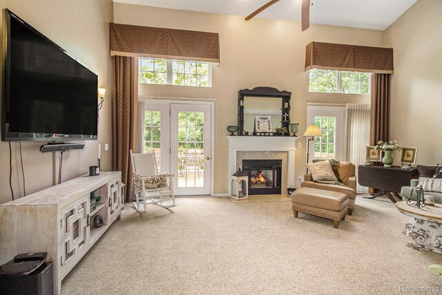 5886 Augusta Ln, Grand Blanc, MI 48439 - living area featuring carpet floors, a towering ceiling, a glass covered fireplace, and ceiling fan