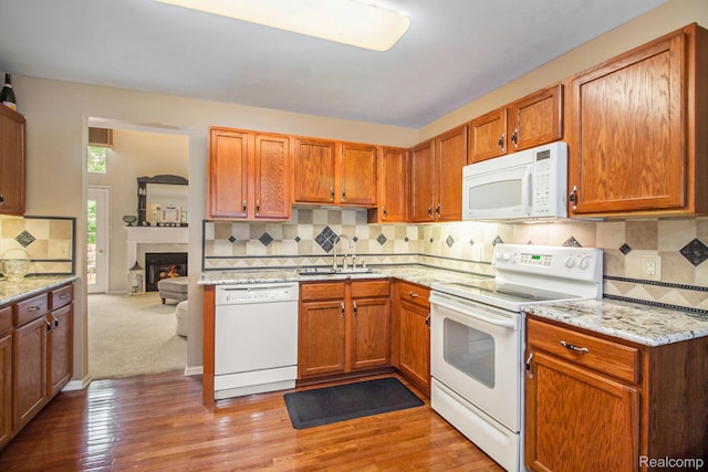 5886 Augusta Ln, Grand Blanc, MI 48439 - kitchen with white appliances, a sink, tasteful backsplash, light stone countertops, and light wood-type flooring