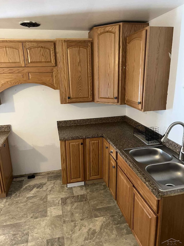 19400 Charest Ave, Detroit, MI 48234 - kitchen with a sink, dark countertops, and brown cabinetry