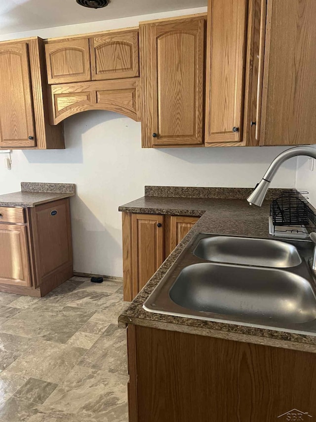 19400 Charest Ave, Detroit, MI 48234 - kitchen with a sink, dark countertops, and brown cabinets