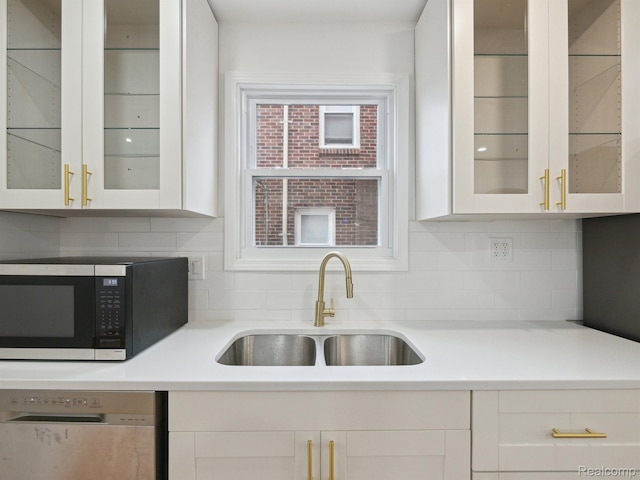 18212 Sorrento St, Detroit, MI 48235 - kitchen featuring appliances with stainless steel finishes, a sink, tasteful backsplash, light countertops, and white cabinetry