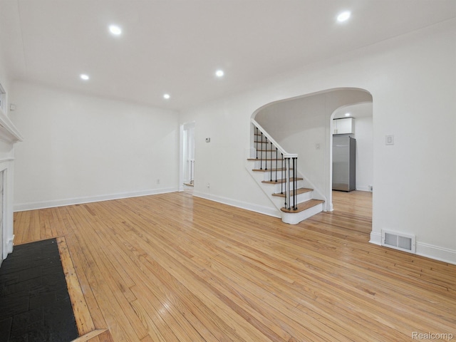 18212 Sorrento St, Detroit, MI 48235 - unfurnished living room with arched walkways, light wood finished floors, stairway, recessed lighting, and baseboards