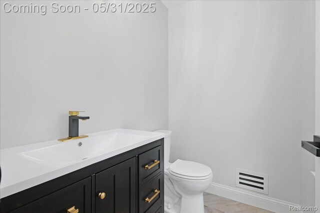 3004 Lansdowne Rd, Waterford, MI 48329 - bathroom with toilet, vanity, baseboards, and wood finished floors
