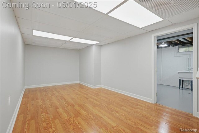3004 Lansdowne Rd, Waterford, MI 48329 - empty room featuring light wood finished floors, a paneled ceiling, and baseboards