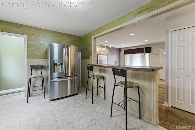 9220 Garden Ter, Commerce Twp, MI 48382 - kitchen featuring stainless steel fridge with ice dispenser, a breakfast bar area, recessed lighting, a wainscoted wall, and butcher block counters