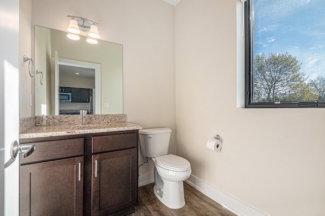 6016 Port View Dr SE, Grand Rapids, MI 49512 - bathroom featuring baseboards, toilet, vanity, wood finished floors, and healthy amount of natural light