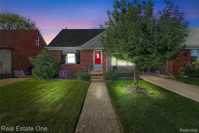 540 Champaign Rd, Lincoln Park, MI 48146 - view of front of property featuring driveway, brick siding, a yard, and roof with shingles
