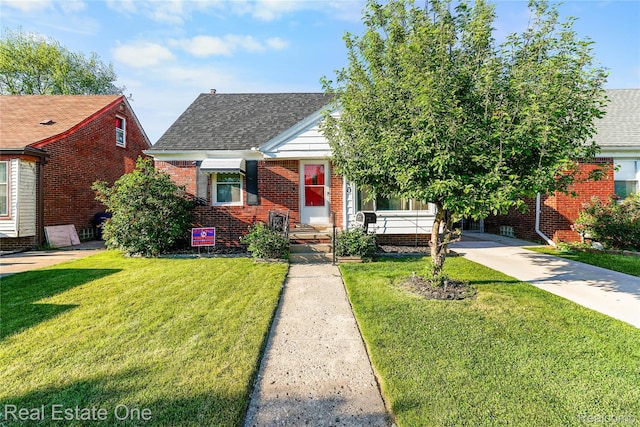 540 Champaign Rd, Lincoln Park, MI 48146 - view of front of property featuring roof with shingles, a front lawn, and brick siding