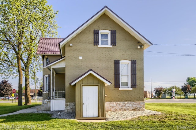9425 W Saginaw Rd, Richville, MI 48758 - rear view of house featuring a yard, metal roof, and brick siding