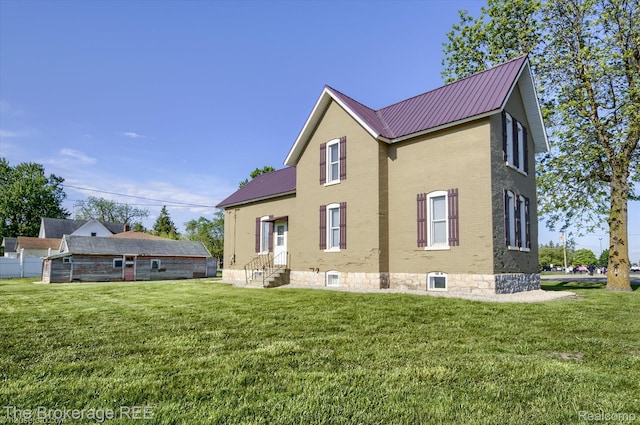 9425 W Saginaw Rd, Richville, MI 48758 - back of property featuring entry steps, brick siding, metal roof, and a yard