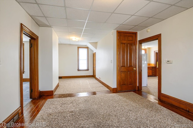 9425 W Saginaw Rd, Richville, MI 48758 - unfurnished room with wood-type flooring, a drop ceiling, and baseboards