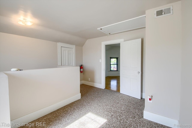 9425 W Saginaw Rd, Richville, MI 48758 - spare room featuring attic access, carpet floors, lofted ceiling, and baseboards