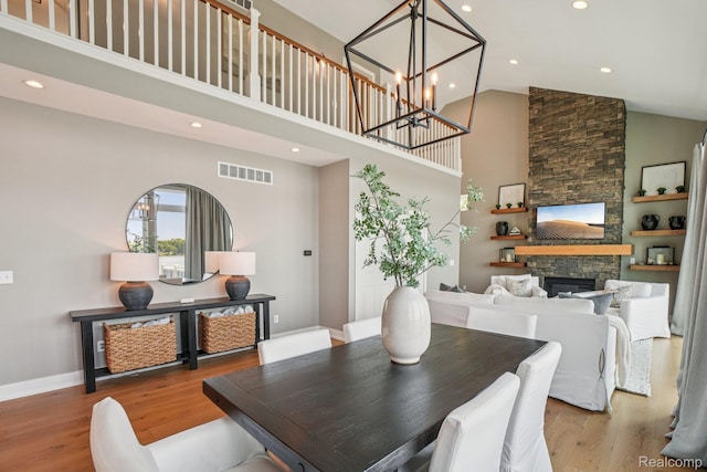 6652 Westminister St, Fenton, MI 48430 - dining space featuring high vaulted ceiling, wood finished floors, recessed lighting, a stone fireplace, and baseboards