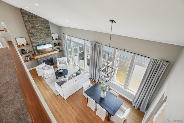 6652 Westminister St, Fenton, MI 48430 - living room with vaulted ceiling, wood finished floors, a stone fireplace, and recessed lighting