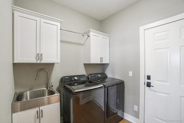 6652 Westminister St, Fenton, MI 48430 - laundry area with cabinet space, washing machine and clothes dryer, and baseboards