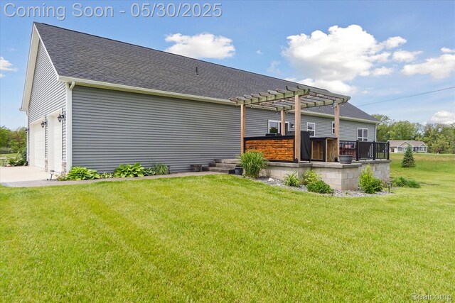 4925 Toratola Ln, Howell, MI 48843 - back of house featuring a pergola, a lawn, roof with shingles, concrete driveway, and a garage