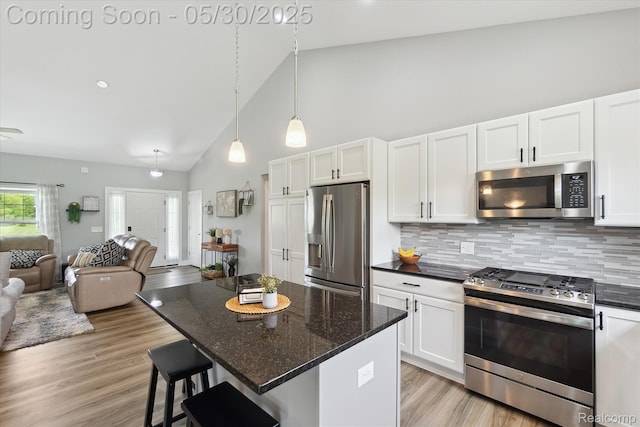 4925 Toratola Ln, Howell, MI 48843 - kitchen featuring stainless steel appliances, open floor plan, white cabinetry, backsplash, and light wood-style flooring