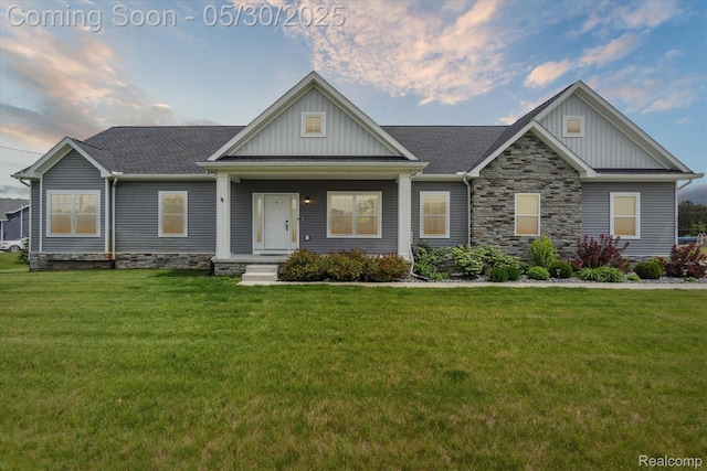 4925 Toratola Ln, Howell, MI 48843 - craftsman inspired home featuring board and batten siding, a front yard, stone siding, and roof with shingles